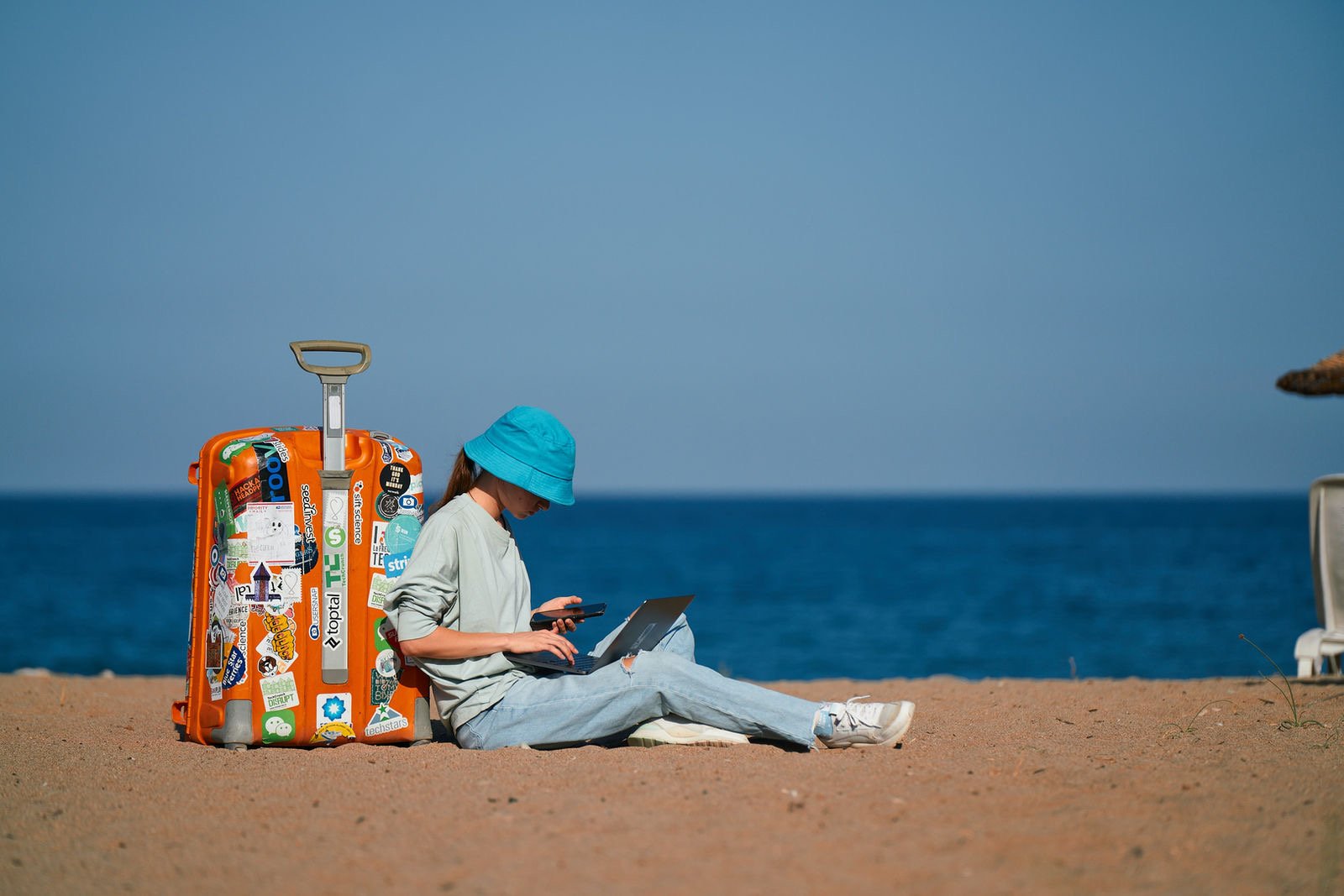 A traveller with a suitcase working on the beach